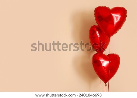 Heart shaped air balloons on beige background. Valentine's day celebration
