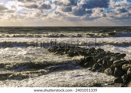 The Black Sea during a storm. An epic seascape. Beautiful sea waves during a storm. Big waves crash on the shore under a cloudy sky. Large waves crash onto the shore. Waves during a storm at sea. 