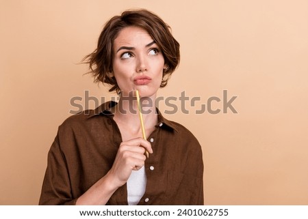 Photo of doubtful suspicious lady wear brown shirt pen chin looking empty space isolated beige color background Royalty-Free Stock Photo #2401062755