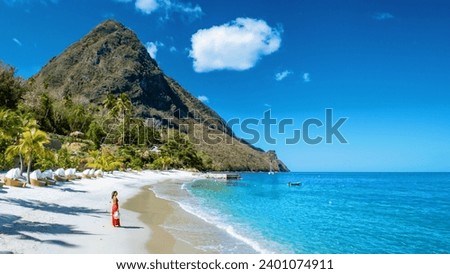 St Lucia Caribbean, woman on vacation at the tropical Island of Saint Lucia Caribbean ocean, an Asian woman in red dress walking on the beach Royalty-Free Stock Photo #2401074911