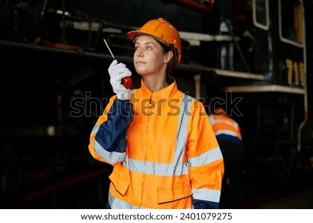 worker using walkie talkie and talking about work at construction train station Royalty-Free Stock Photo #2401079275