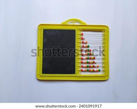 Closeup of Plastic Colorful Beeds for Abacus , Black Board Slate with Chalk Piece isolated on white background Royalty-Free Stock Photo #2401091917