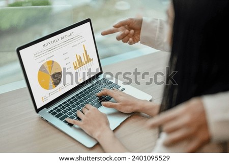 Cropped shot of two marketing specialist analyzing graphs and charts on laptop screen.