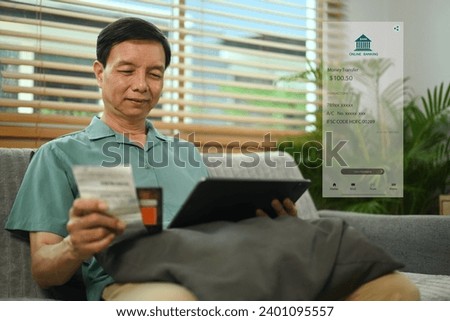 Happy senior man using online payment methods, banking on digital tablet.