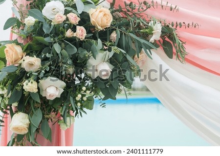 A piece of wedding arch adorned with flowers and cloth. Flower arrangement consists of different types of roses and greenery Royalty-Free Stock Photo #2401111779