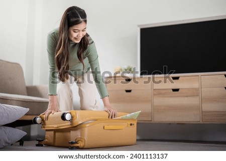 Beauty asian traveler woman packing prepare stuff and outfit clothes in suitcase travel bag luggage for holidays at home, weekend, tourist, journey Royalty-Free Stock Photo #2401113137