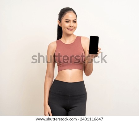 Young beautiful asian woman with sportswear using smartphone on isolated white background. Attractive Portrait latin sporty woman standing pose holding cell phone exercise workout in studio. Royalty-Free Stock Photo #2401116647
