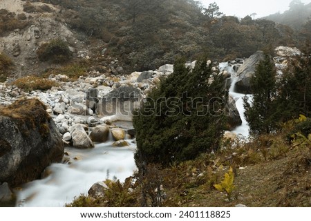 View of Bhote Koshi river in the fog in Thame during Three passes trekking in Himlayas, Khumbu region, Nepal, Asia. Long exposure photography.