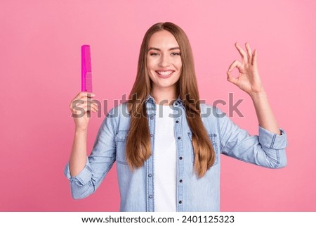 Photo portrait of lovely young lady hold hair comb show okey symbol dressed stylish denim garment isolated on pink color background
