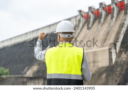 Professional asian maintenance engineer man with safety helmet in construction site dam with hydroelectric power plant and irrigation. Manager engineer man working at project big building.