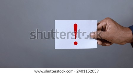 Hand picks up paper with exclamation mark Warning and caution concepts Precautions and risk management safety signs Danger announcement and danger warning symbols