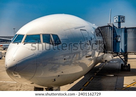Beautiful image of an airline wide-body commercial jet parked at John F. Kennedy International Airport, where it is being loaded at gate 12 to begin a new journey on a new course. Royalty-Free Stock Photo #2401162729