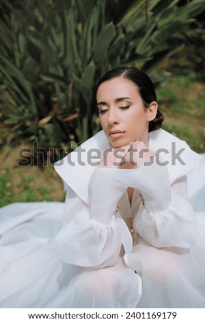 Young girl in a white dress walking in the park with make up and hair style. chiffon dress