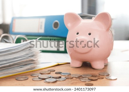 Savings money with piggy bank concept. Coins and papers on desk