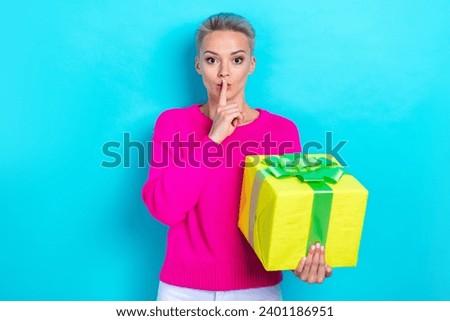 Photo of pleasant woman with bob hairdo dressed pink sweater holding gift box finger on lips keep secret isolated on teal color background