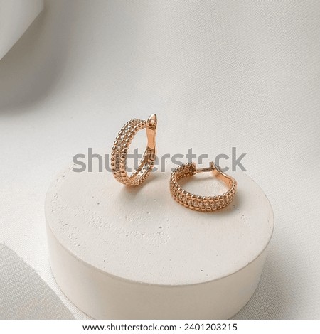 Stylish gold earrings with English lock and cubic zirconia. Royalty-Free Stock Photo #2401203215