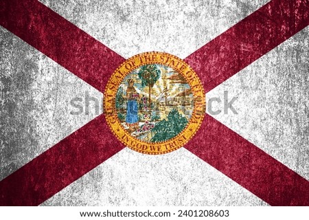 Close-up of the grunge Florida state flag. Dirty Florida state flag on a metal surface.