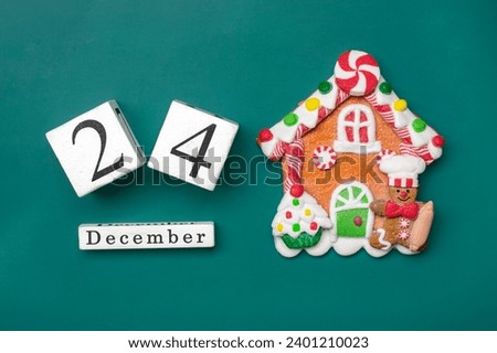 Christmas Gingerbread house, wooden calendar date 24 December isolated on green background Concept Xmas preparation, atmosphere Wishes card Handmade Royalty-Free Stock Photo #2401210023