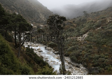View of Bhote Koshi river in the fog in Thame during Three passes trekking in Himlayas, Khumbu region, Nepal, Asia. Long exposure photography.
