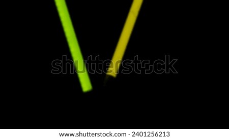 Blurred green and yellow neon lights at night. Neon lights with black background. The concept of abstract blurred light, nightlife, and darkness. Background green and yellow neon with copy space.