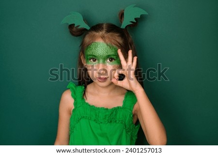 Little lady dressed in a dragon costume showing OK sign, making okay gesture with fingers. Waiting for the New year 2024