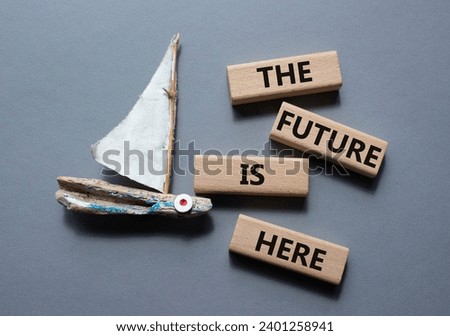 The future is here symbol. Concept words The future is here on wooden blocks. Beautiful grey background with boat. Business and The future is here concept. Copy space.