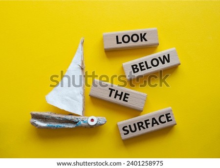 Look below the surface symbol. Concept word Look below the surface on wooden blocks. Beautiful yellow background with boat. Business and Look below the surface concept. Copy space