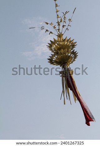 traditional pole sign called penjor made of yellow coconut leaves and bambu pole