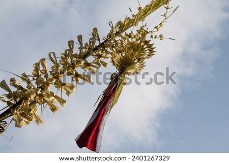 traditional pole sign called penjor made of yellow coconut leaves and bambu pole