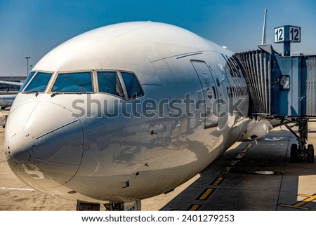 A commercial airframe aircraft parked at John F. Kennedy International Airport, where it is being loaded for a new journey on a new course. Royalty-Free Stock Photo #2401279253