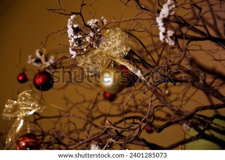 Christmas decoration made with balls and dry branches, in gold, red and brown tones