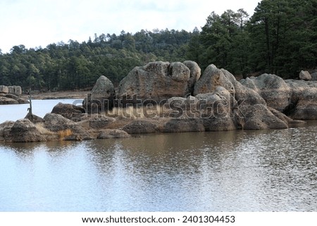 landscape with calm lake water trees and large stone blocks