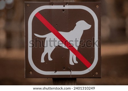 Informative sign about dog being not allowed to enter beyond this sign. A sign with the image of a dog crossed with red line