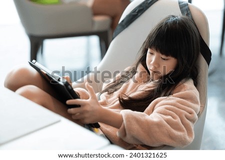 Kid watching tablet on the food table, children addicted cartoon

