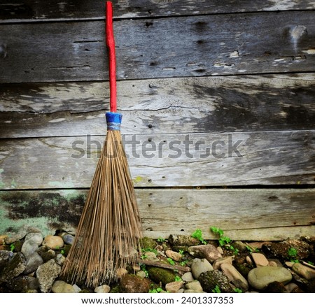 A red broom stick on a wooden wall