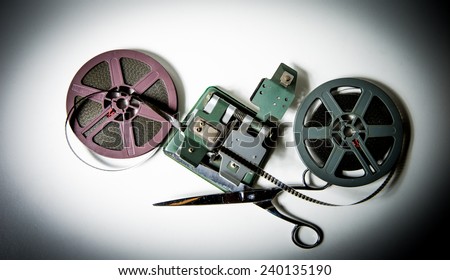 Couple of grey and purple 8mm super8 movie reels, a splicer and scissors on white background, vintage look and color effect