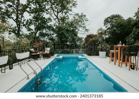 A swimming pool typically consists of a water-filled basin, often constructed from concrete, fiberglass, or vinyl. Royalty-Free Stock Photo #2401373185