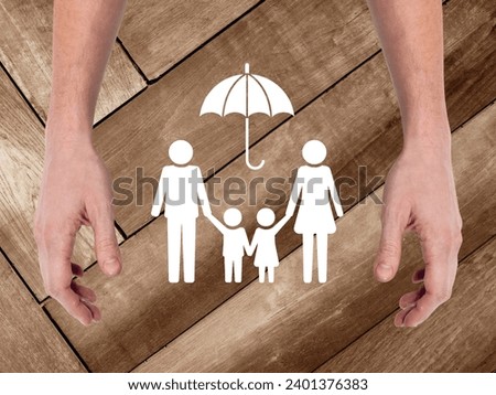 Hands hold family figure. Health insurance concept. High angle view.