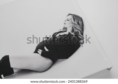The cover of a photo book with a black and white photo of a pregnant blonde. Pregnancy photo shoot as a keepsake. Beautiful and convenient storage of photos. Professional photo printing.