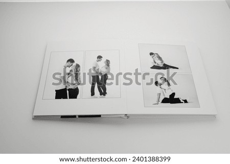The pages of a photo book with a black and white photo of a pregnant blonde and a man. Pregnancy photo shoot as a keepsake. Professional photo printing.
