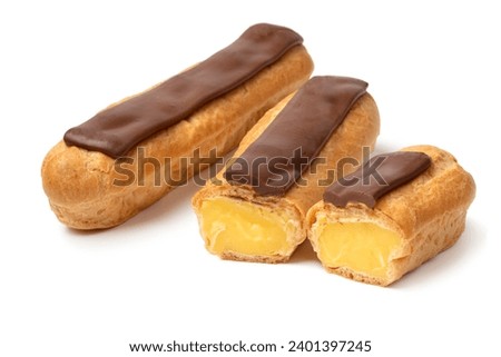 Whole and halved traditional French eclair isolated on white background close up Royalty-Free Stock Photo #2401397245