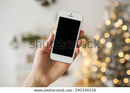 White smartphone with the christmas tree in background