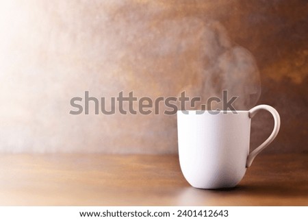 drink, mug with steam escaping from the hot cup. Close-up on brown gradient background, autumn tones, tea, coffee, chocolate, mulled wine, on a vintage table.  Royalty-Free Stock Photo #2401412643
