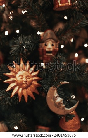 Christmas tree branches decorated with golden glossy Christmas toys sun and moon. Festive photo for banner, poster, cover, brochure, card or presentation.