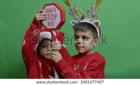 Naughty brothers inviting santa to come. Dancing and grabbing the sign. High quality photo