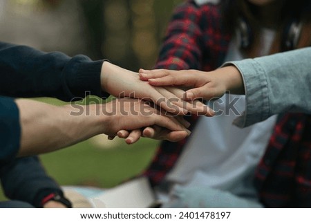 Close-up image of group of university students stacking hands together symbolizes unity and friendship supporting.