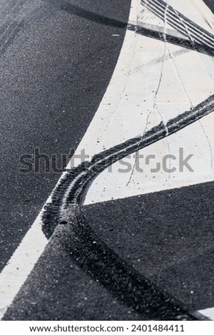 Black rubber tire marks in a street.