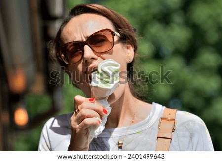 Close-up of a woman's mouth licking sweet ice cream with her tongue