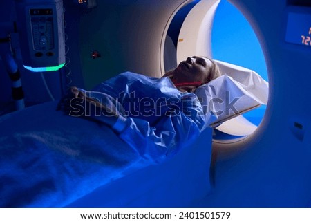 Female patient undergoing contrast-enhanced chest computed tomography Royalty-Free Stock Photo #2401501579