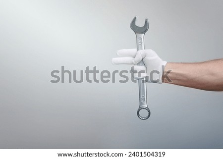 a worker, builder, repairman, handyman, hands with protection glove holding wrench on white background. Mock up copy space